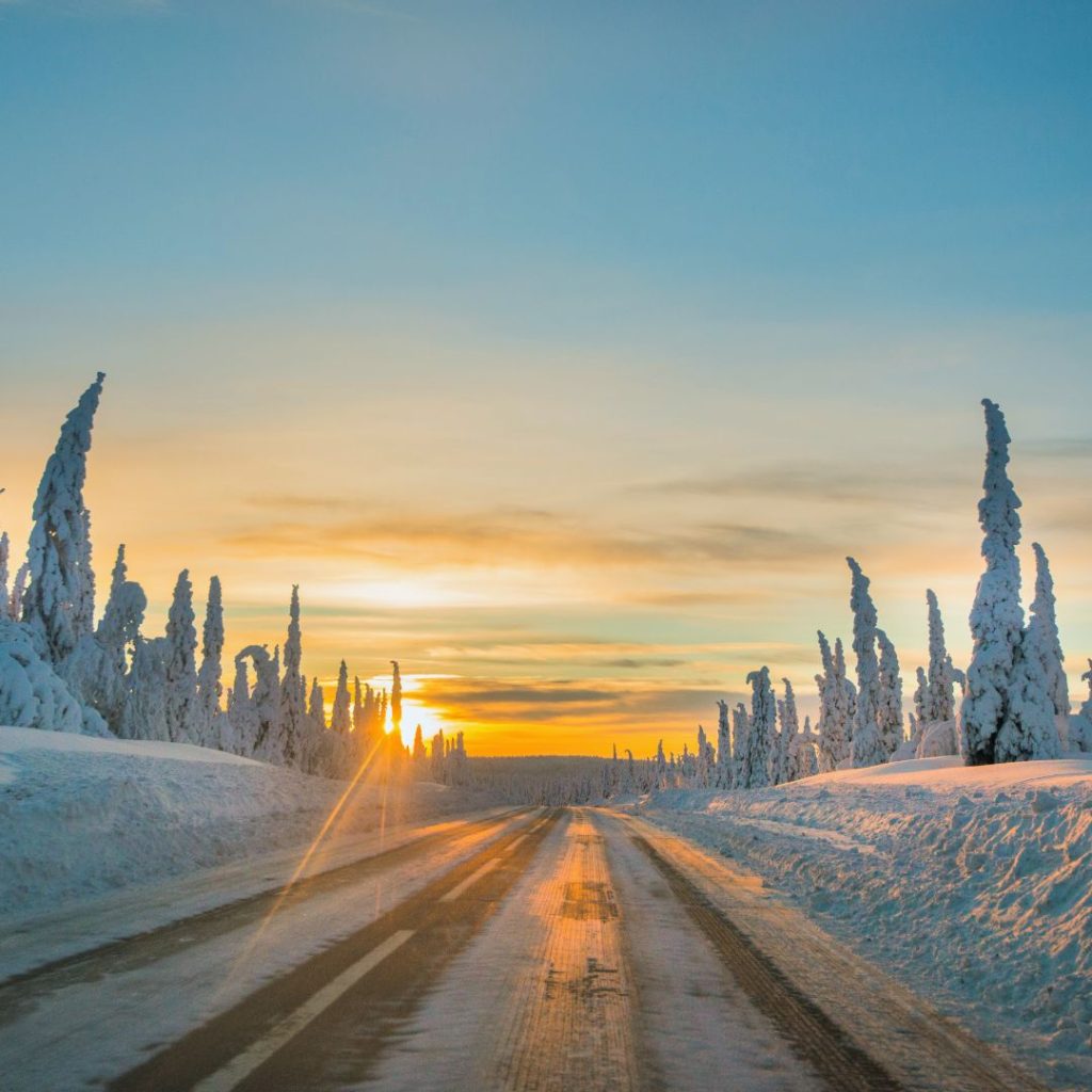 snowy road with the sunset in the distance